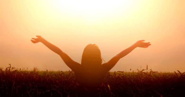 estilo de vida natural | Menina levanta as mãos para o céu e sente liberdade.