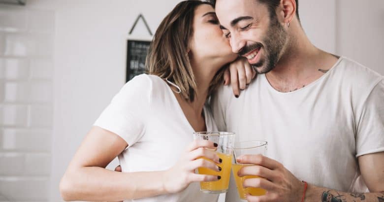 Mulher, beijando, homem, enquanto desfruta de suco | 5 Sucos Detox Para Melhorar a Saúde de Forma Natural