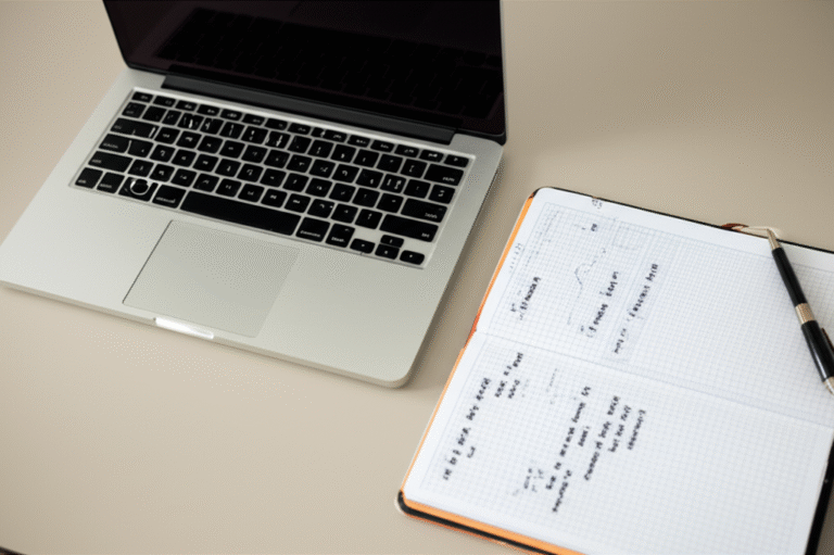 Planejamento Financeiro para Nômades Digitais Laptop e caderno com anotações financeiras sobre uma mesa de madeira